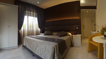 Une chambre moderne avec un grand lit, une table de chevet, une chaise et un appareil de climatisation.