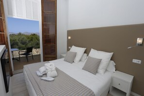 A bedroom with a bed, bedside tables, a desk, and a chair. - Prinsotel Mal Pas (Alcúdia)