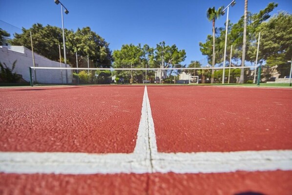 A red running track with white lines, surrounded by trees and a fence. - Prinsotel Mal Pas (Alcúdia)