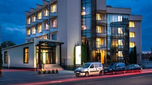 A modern hotel with multiple floors, large windows, and a well-lit entrance. - Hotel Opal (Cluj-Napoca)