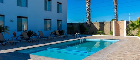 Outdoor pool, open 8:00 AM to 8:00 PM, pool umbrellas