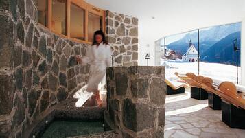 Relax in a serene spa area with a view of the surrounding mountains.