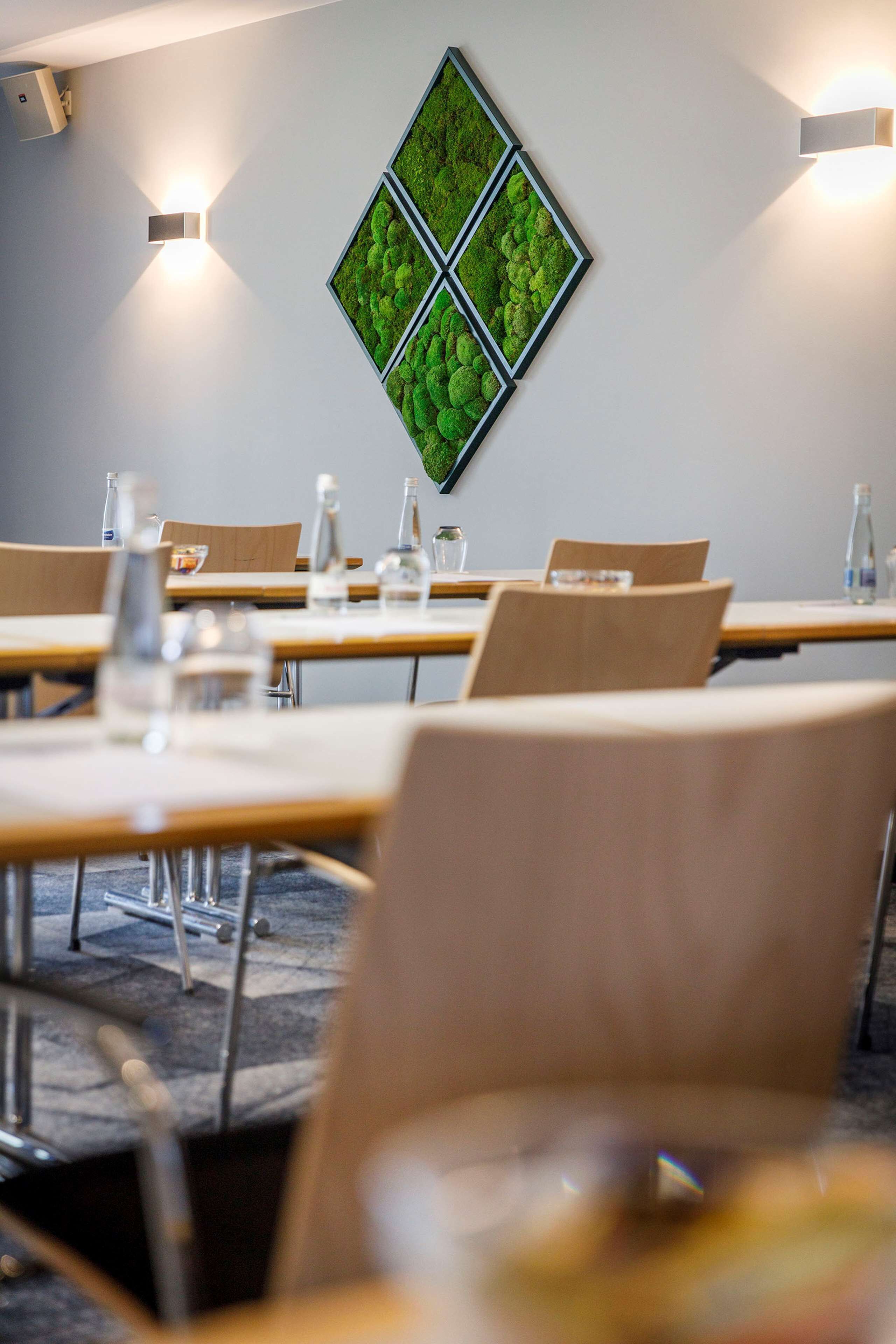 A conference room with tables, chairs, and a wall-mounted light fixture.