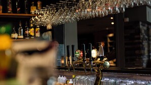 Un espace bar doté de plusieurs robinets à bière et d’une variété de bouteilles disposées en arrière-plan.