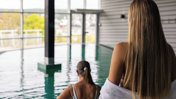 Un espace piscine avec vue sur un immeuble et des arbres.