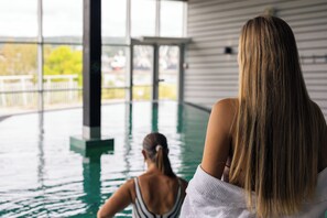 Zona de piscina con vistas a un edificio y árboles.
