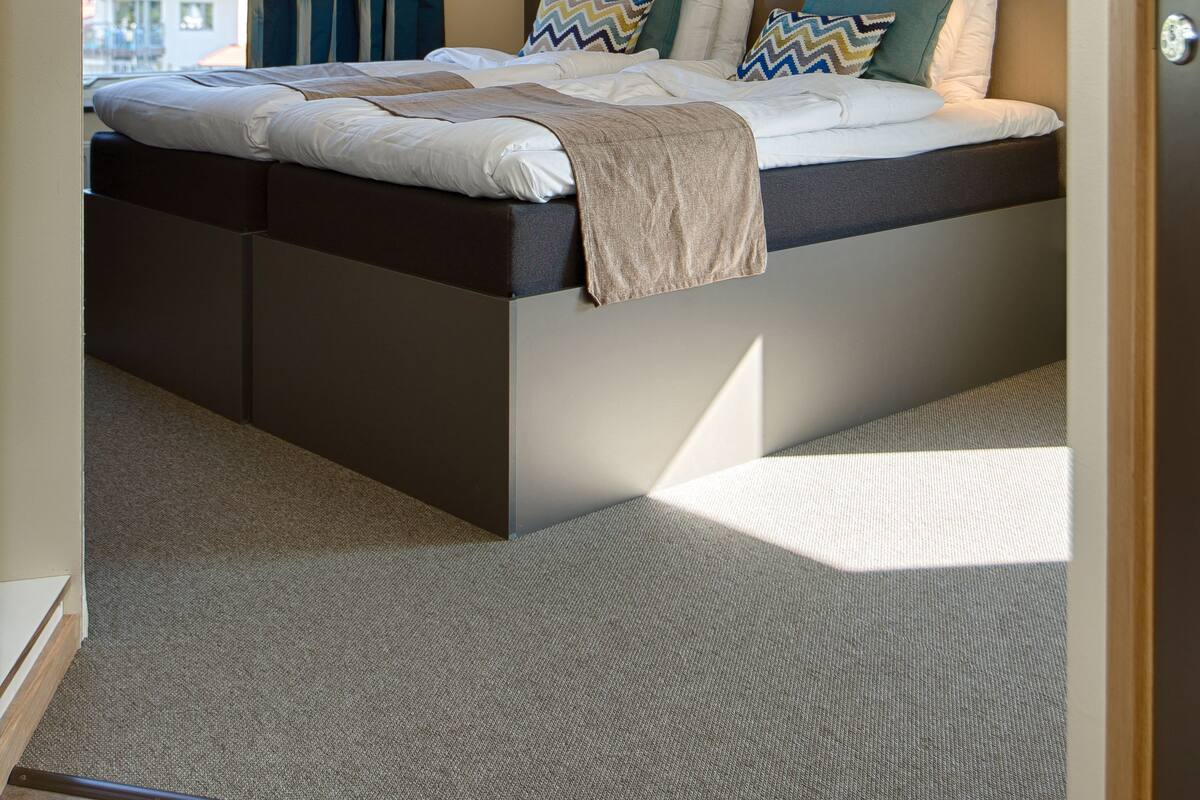 Une chambre à coucher moderne avec un lit, des rideaux et une table de chevet.