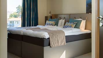A modern bedroom with a bed, curtains, and a nightstand.