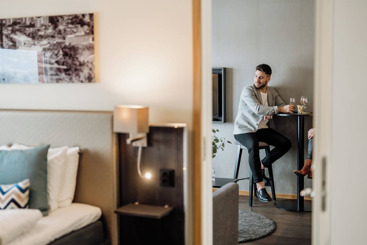 Une chambre d’hôtel moderne, équipée d’un lit, d’un bureau et d’une chaise.