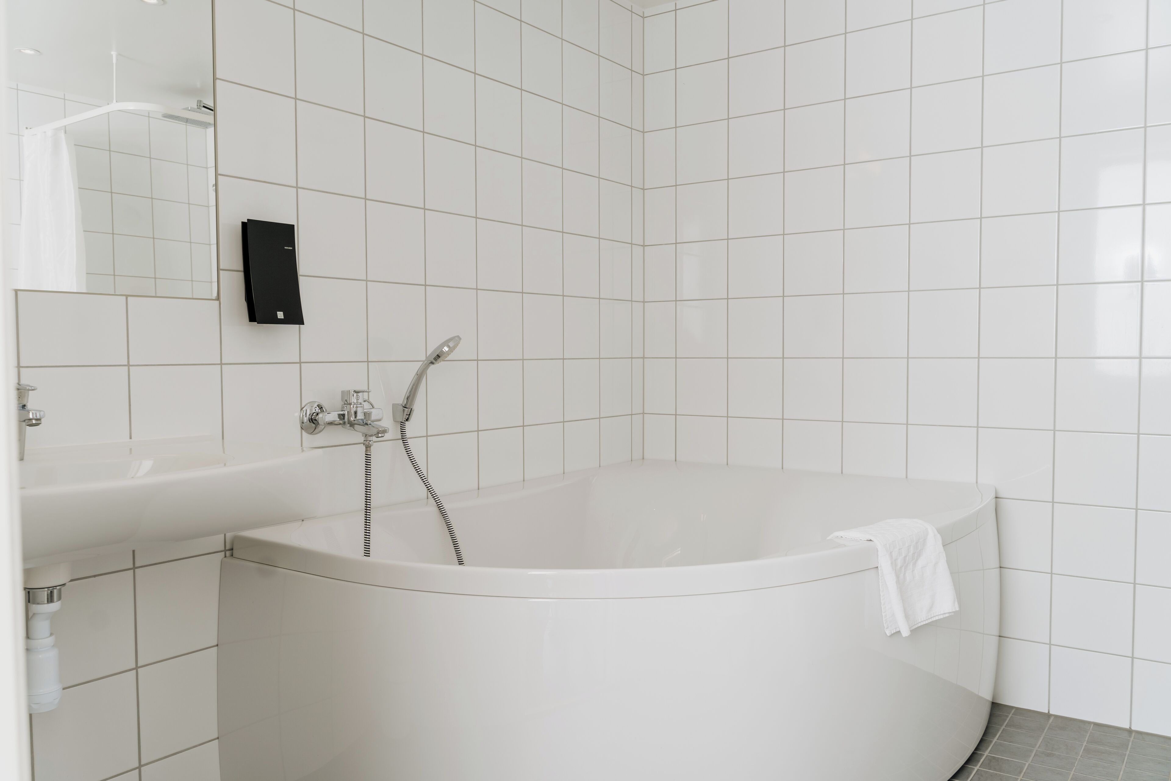 Un baño moderno con una bañera independiente, un lavabo y un espejo.