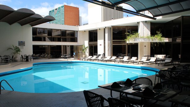Una piscina al aire libre, sillones reclinables de piscina