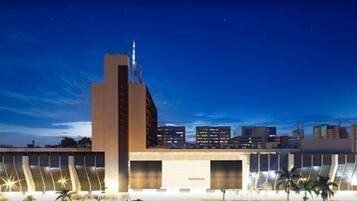 Un edificio moderno con una torre destacada y varias entradas tipo garaje.