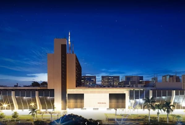 Un edificio moderno con una torre destacada y varias entradas tipo garaje.