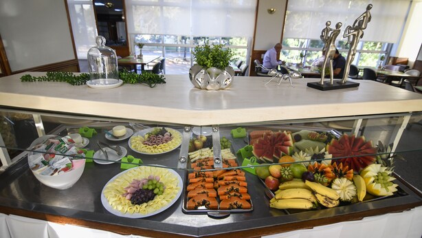 A buffet counter with various food items and a decorative glass display. - Like U Hotel Brasilia (Brasília)
