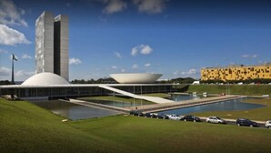 A modern building with a large dome and a tall tower, surrounded by a landscaped area with a pool and parked cars. - Like U Hotel Brasilia (Brasília)