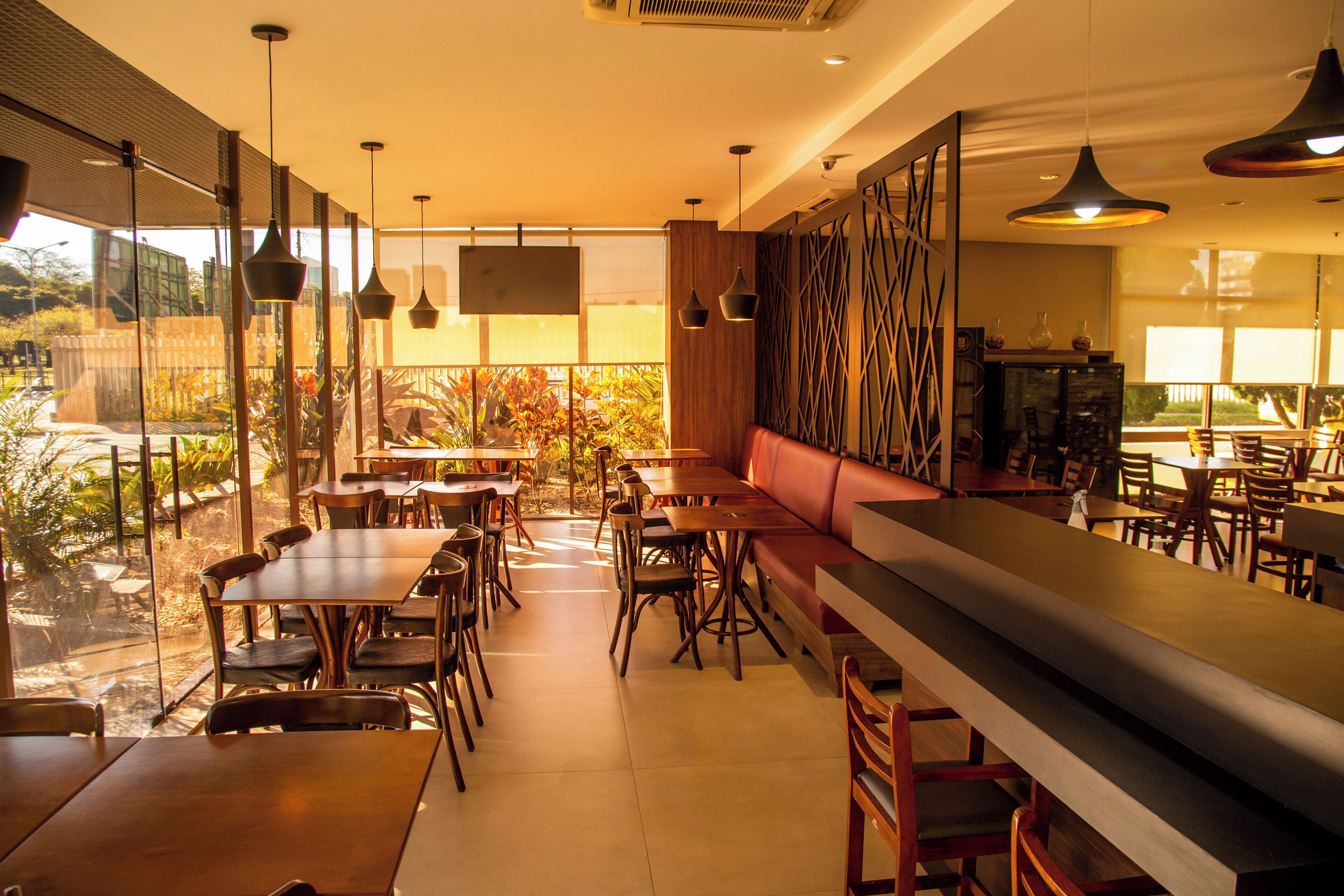 Ein Restaurant mit Barbereich, Sitzgelegenheiten und Blick ins Freie.