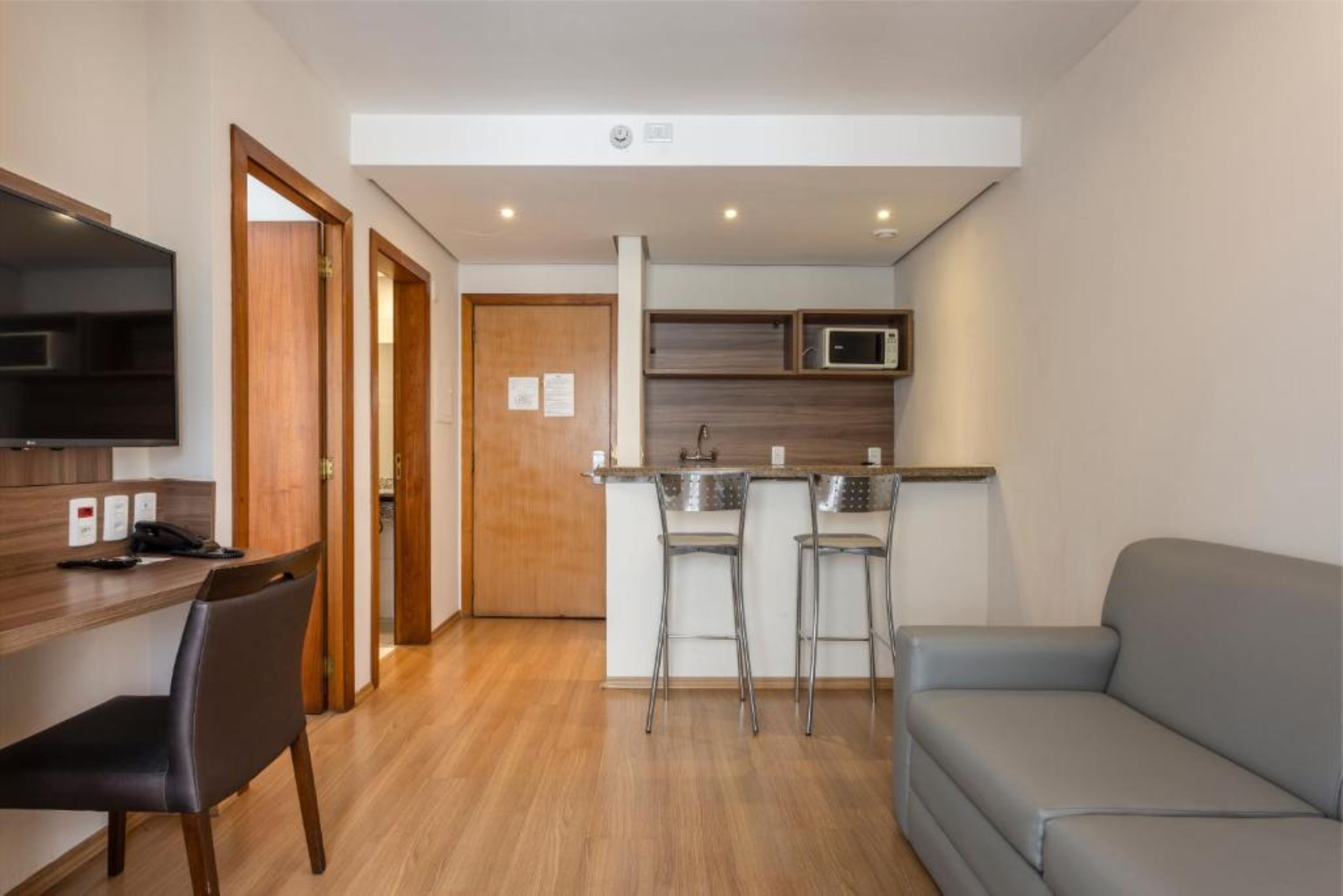 A compact living space with a kitchenette, a dining area, and a seating area.