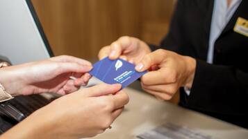 Une personne qui remet une carte bleue à une autre personne.