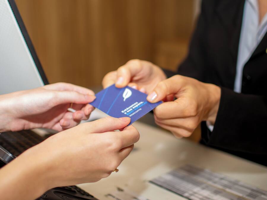Une personne qui remet une carte bleue à une autre personne.