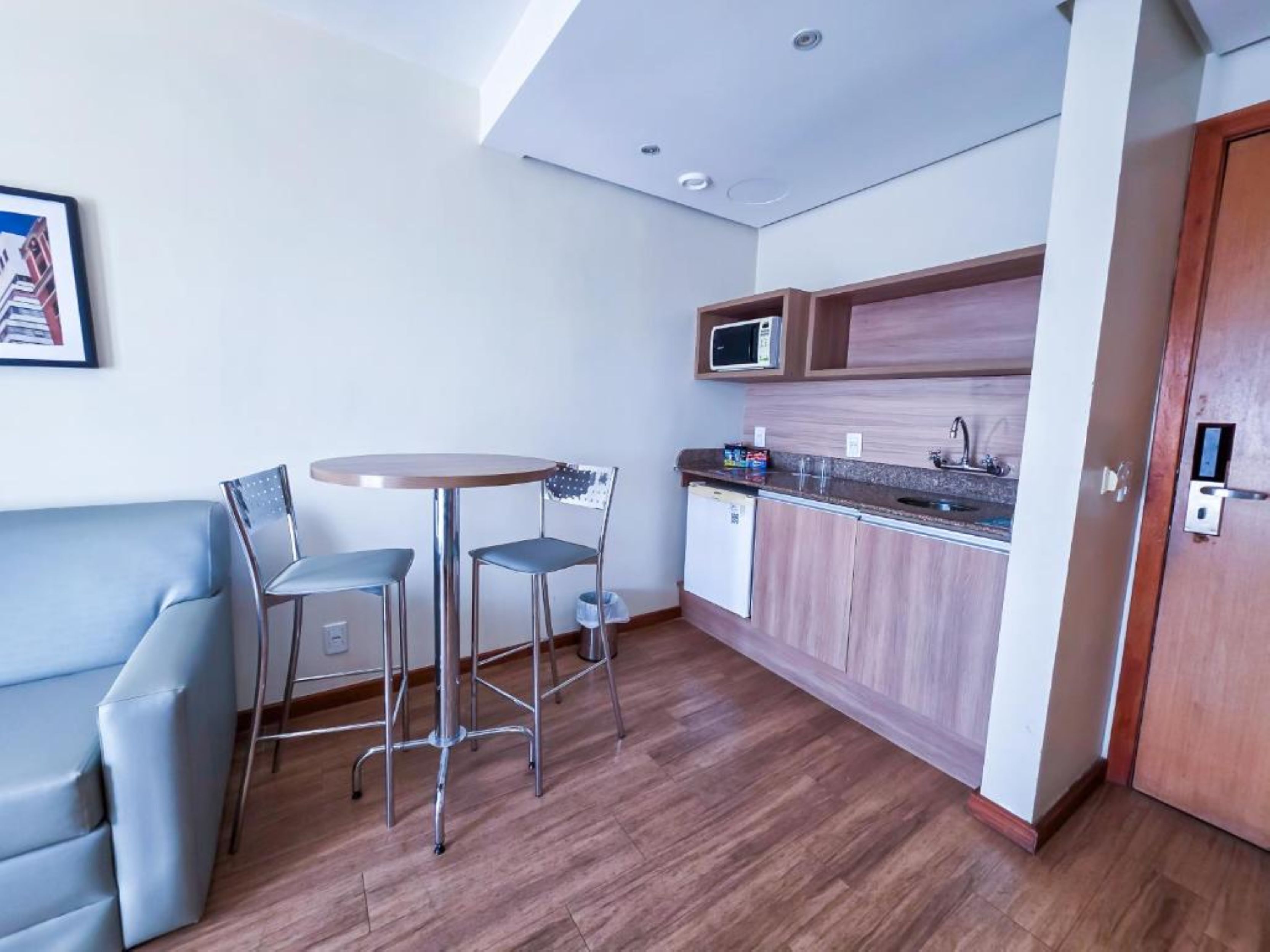 Una cocina compacta con comedor, microondas y refrigerador.