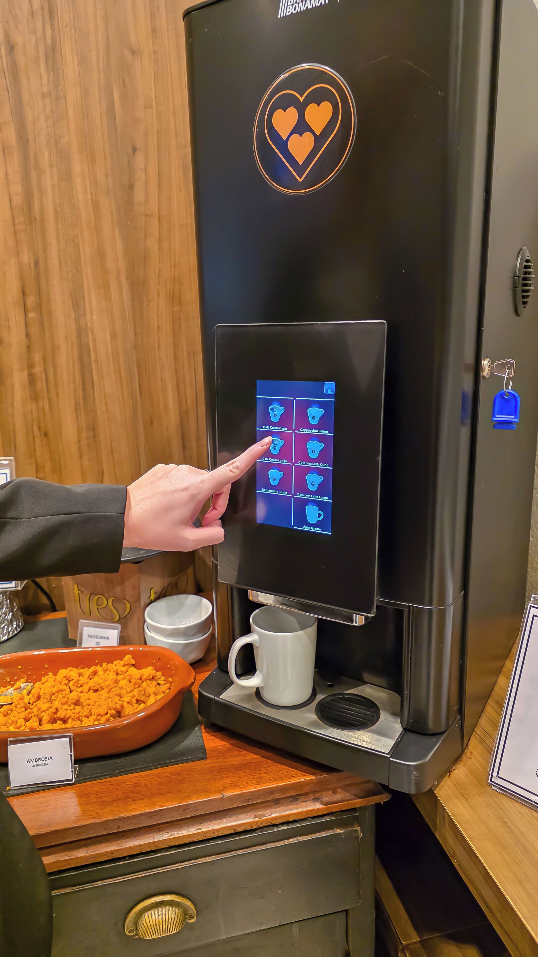 A coffee machine with a digital interface and a cup placed underneath.