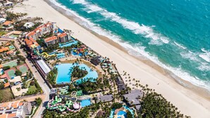 An aerial view of a resort with a beach, a water park, and multiple swimming pools. - Beach Park Acqua Resort (Aquiraz)