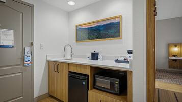 A compact kitchen with a microwave, dishwasher, and a sink.