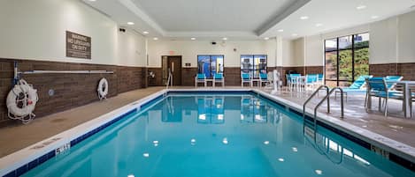 Une piscine dotée d’un poste de surveillance pour les sauveteurs, d’un panneau indiquant l’absence de sauveteur, et offrant une vue sur l’extérieur grâce à de grandes fenêtres.