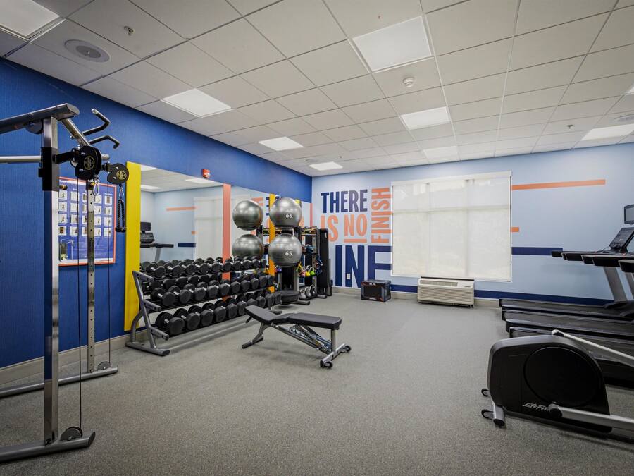A gym with exercise equipment, treadmills, and a motivational wall.