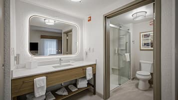 Ein modernes Badezimmer mit großem Spiegel, Waschbecken, Dusche und Toilette.