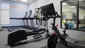 A gym with treadmills, a stationary bike, and a rowing machine.