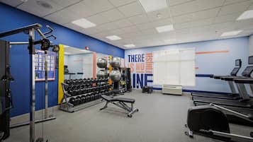 A gym with exercise equipment, treadmills, and a motivational wall.
