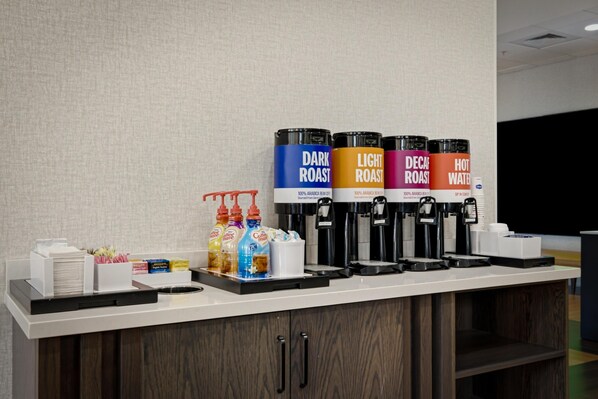 A coffee station with four dispensers labeled DARK ROAST, LIGHT ROAST, DECA ROAST, and HOT WATER. - Hampton Inn Hickory (Hickory)