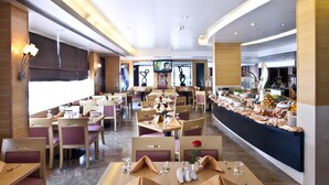 A restaurant with multiple dining tables set for guests, featuring neatly arranged cutlery and napkins. - Landmark Hotel Riqqa (Dubai)