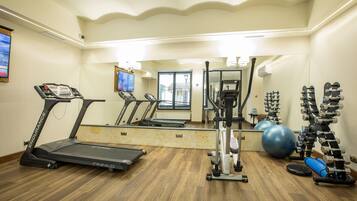 A gym with treadmills, an elliptical, a stationary bike, and exercise balls.