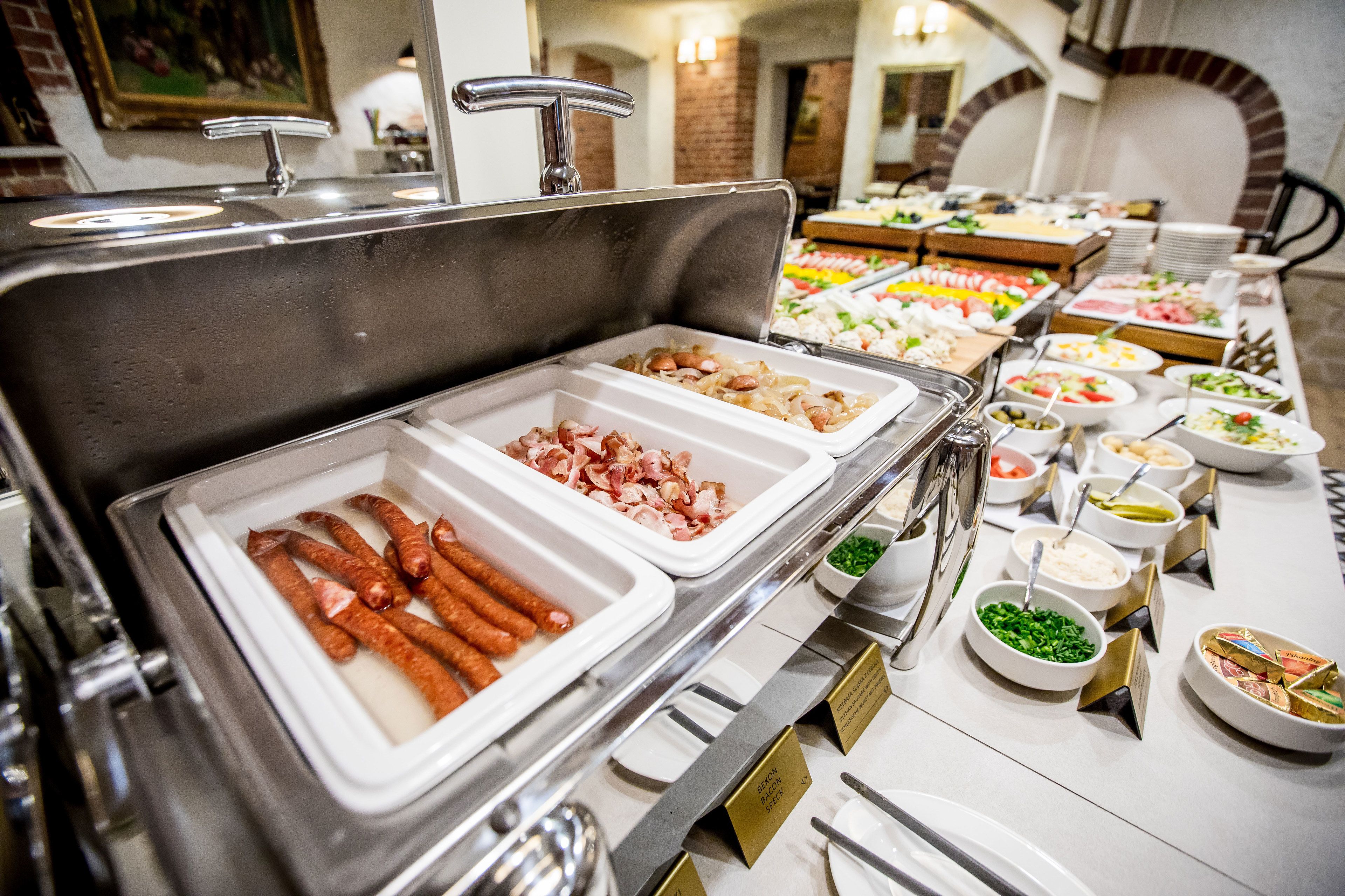 A buffet with various food options including sausages, meats, and salads.