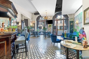 Un vestíbulo de hotel con piso a cuadros, zonas de estar y un bar.