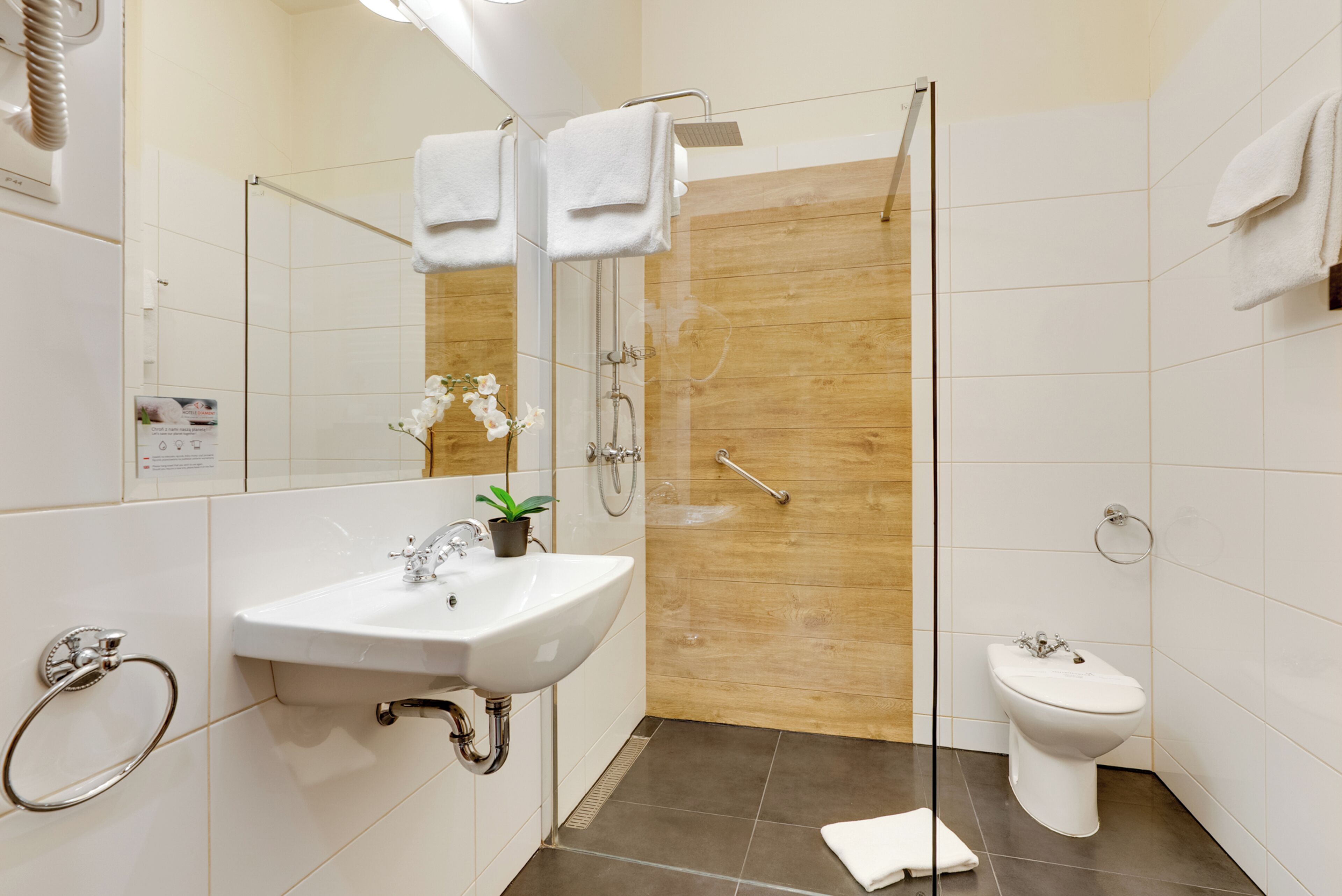 Un baño moderno con lavamanos, inodoro y ducha.