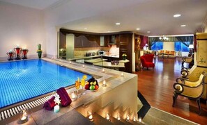 Un vestíbulo de hotel con piscina, comedor y zona de estar con vistas a la ciudad.