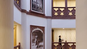 A multi-level interior with ornate railings and framed artwork on the walls. - Al Safir Hotel & Tower (Manama)