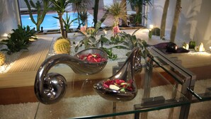 Een glazen vitrine met diverse decoratieve objecten, waaronder een cactus en een bloemenvaas, in een goed verlichte ruimte.