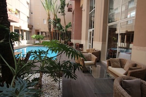 Una piscina al aire libre, sombrillas, tumbonas