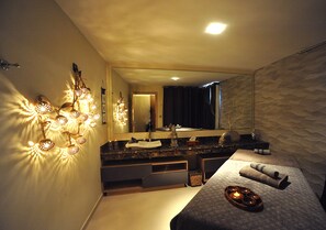 Een moderne slaapkamer met een groot bed, een kaptafel met spiegel en een wandlamp.