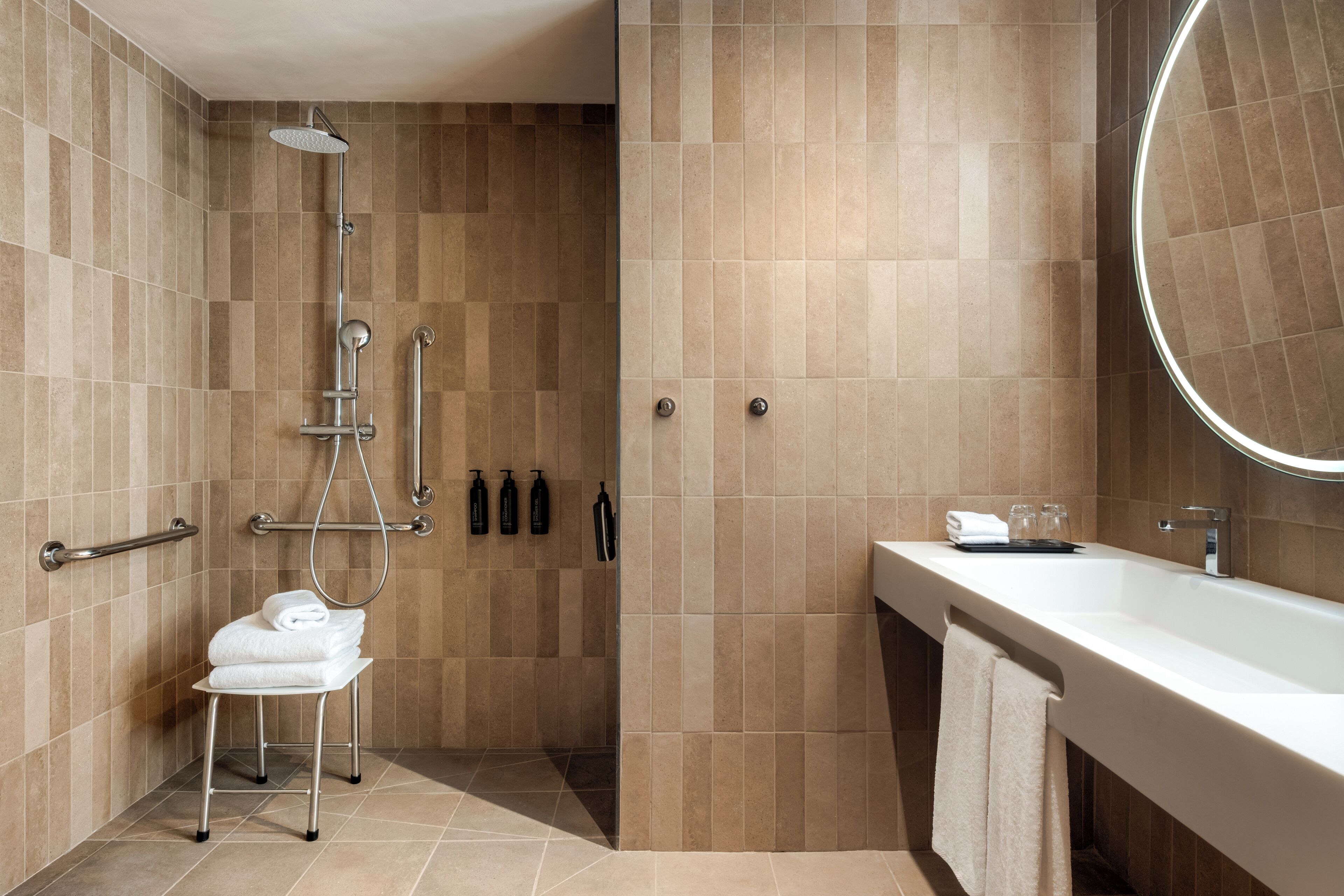 Et moderne badeværelse med bruser, toilet og vask.
