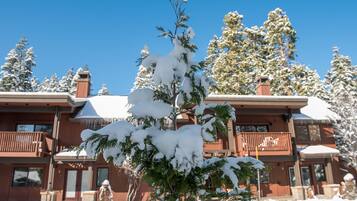 A two-story building with a snow-covered roof and a balcony.