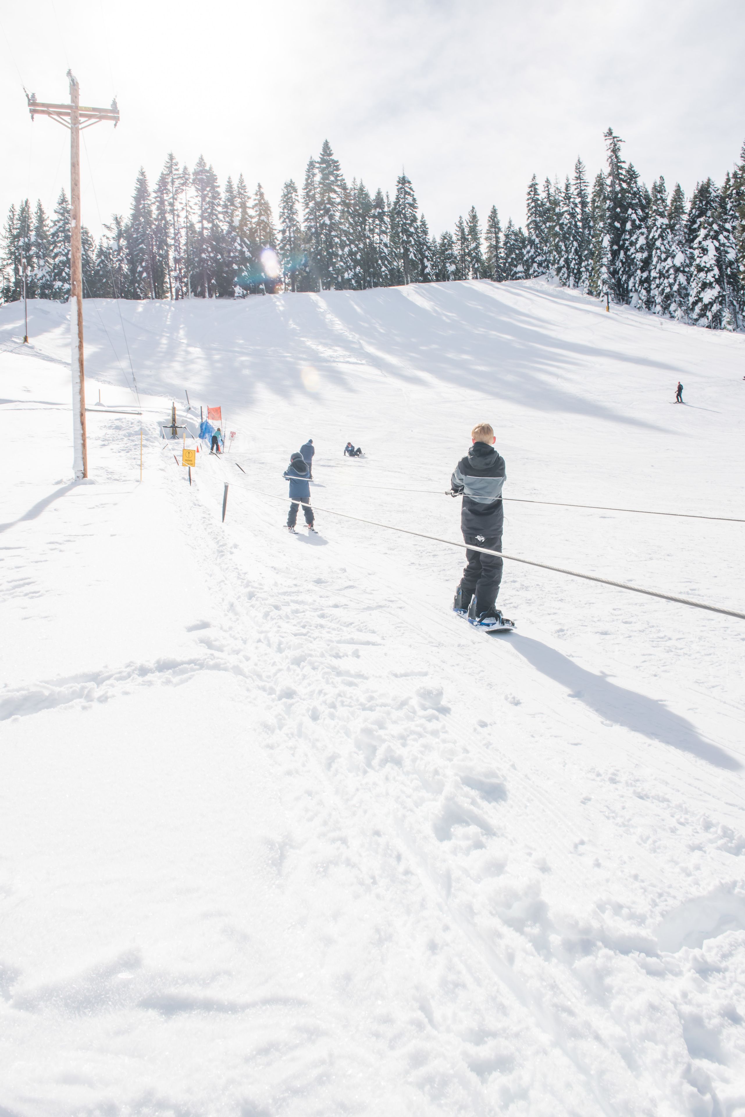 A snowy ski slope with skiers and a ski lift.