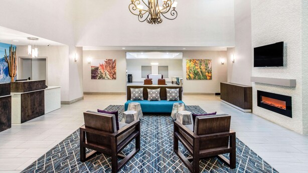 A spacious lobby with a high ceiling, a chandelier, a sofa, and a fireplace. - La Quinta Inn & Suites by Wyndham Hillsboro (Hillsboro)
