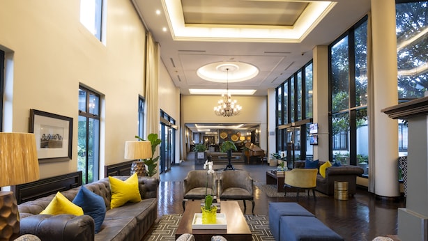 A spacious lobby with a modern design, featuring leather sofas, patterned chairs, and a central coffee table. - ANEW Hotel Hilton Pietermaritzburg (Hilton)