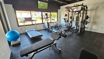Ett gym med träningsredskap, ett löpband och en blå träningsboll.