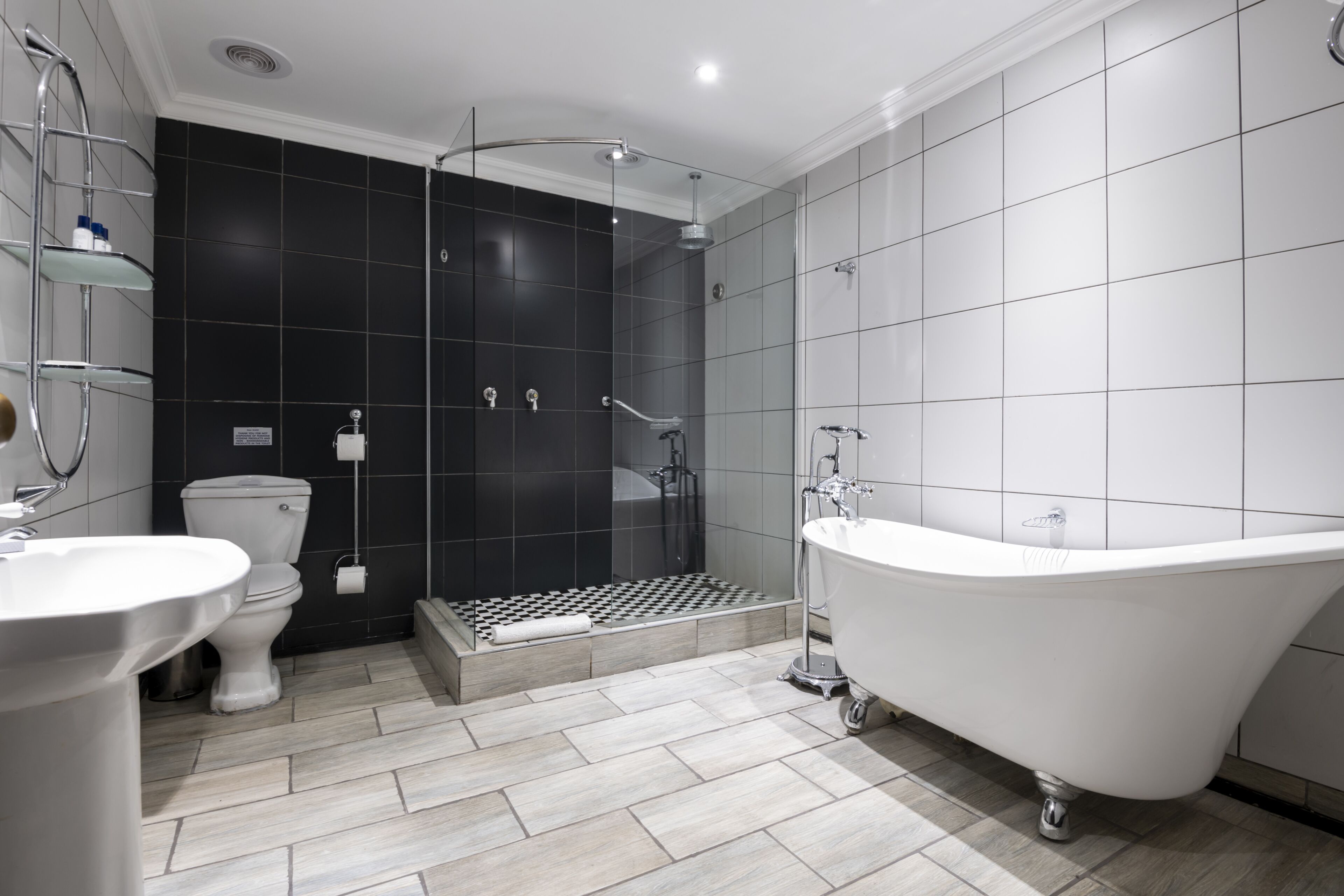 A modern bathroom with a freestanding bathtub, a toilet, and a shower area.